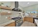 Modern kitchen featuring a large range, custom vent hood, and ample counter space at 2160 Pueblo Cir, Las Vegas, NV 89169