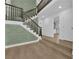 Elegant foyer with a wooden staircase, accented by a decorative green wall and views of the home's interior at 2160 Pueblo Cir, Las Vegas, NV 89169