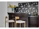 Stylish wet bar with flamingo wallpaper, dark cabinets, and seating at 2160 Pueblo Cir, Las Vegas, NV 89169