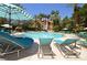 Beautiful community pool area with plenty of lounge chairs and sun umbrellas under a clear blue sky at 260 E Flamingo Rd # 228, Las Vegas, NV 89169