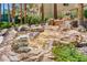 Peaceful waterfall feature surrounded by native desert vegetation and large mature shade trees at 260 E Flamingo Rd # 228, Las Vegas, NV 89169