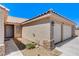 Close-up of home's entrance and garage, featuring stone accents and tidy landscaping at 2848 Skowhegan Dr, Henderson, NV 89074