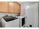 Laundry room with modern washer and dryer units and upper cabinets at 2848 Skowhegan Dr, Henderson, NV 89074