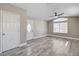 Open living room with wood-look flooring, a ceiling fan, and a front door with decorative glass at 2848 Skowhegan Dr, Henderson, NV 89074