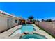 A backyard features a sparkling pool and spa combo, a covered patio, and mature trees at 2848 Skowhegan Dr, Henderson, NV 89074