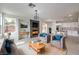 Cozy living room with a stone fireplace, modern furniture, and an open layout connected to the kitchen at 3065 Blue Monaco St, Las Vegas, NV 89117