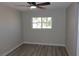 Bright bedroom features a ceiling fan, wood-look floors, and a window with natural light at 3219 Bluebird St, Las Vegas, NV 89121
