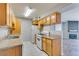 Charming kitchen featuring wood cabinets and marble-look tile with an adjacent living area at 3318 N Decatur Blvd # 2110, Las Vegas, NV 89130