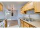 Bright kitchen with a double sink, wood cabinets, and marble-look tile adjacent to dining area at 3318 N Decatur Blvd # 2110, Las Vegas, NV 89130