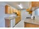 Well-lit kitchen featuring wood cabinetry, marble-look tile flooring and a gas stove at 3318 N Decatur Blvd # 2110, Las Vegas, NV 89130