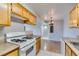 Bright kitchen with a gas range, wood cabinets, and marble-look tile leading to dining area at 3318 N Decatur Blvd # 2110, Las Vegas, NV 89130