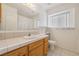 Bathroom features a window, a sink with a tile countertop, and a walk-in shower at 3581 Mallard Ave, Pahrump, NV 89048