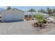 A home's exterior boasts a circular driveway, mature landscaping, and an attached garage with white garage doors at 3581 Mallard Ave, Pahrump, NV 89048