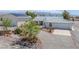 Landscaped front exterior view showcasing a home with desert landscaping, circular driveway and detached garage at 3581 Mallard Ave, Pahrump, NV 89048