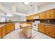 Bright kitchen with wood cabinets, a center island, and modern white appliances at 3581 Mallard Ave, Pahrump, NV 89048
