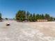 Spacious vacant land showcasing mature trees, partial fencing, and possibilities for development at 3581 Mallard Ave, Pahrump, NV 89048