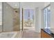 Modern bathroom with a glass shower, separate tub and a large window that showcases city views at 3726 Las Vegas Blvd # 1902, Las Vegas, NV 89158