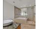 Well lit bathroom featuring a soaking tub and glass enclosed shower at 3726 Las Vegas Blvd # 1902, Las Vegas, NV 89158