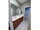 Bathroom featuring a double sink vanity, a well-lit mirror, and a view into a separate toilet area at 3964 Irvin Ave, Las Vegas, NV 89141