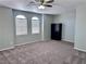 A spacious bedroom featuring neutral walls, carpet flooring, two arched windows, and a ceiling fan with lighting at 3964 Irvin Ave, Las Vegas, NV 89141