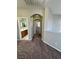 Hallway with cozy brown carpet leading to an arched entry and a bathroom with a wood vanity at 3964 Irvin Ave, Las Vegas, NV 89141