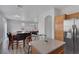 Open floor plan shows kitchen island, stainless steel refrigerator and adjacent dining table with seating for six at 3964 Irvin Ave, Las Vegas, NV 89141