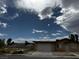 Exterior shot of the home showing the front facade, driveway, and the surrounding neighborhood at 4189 Studio St, Las Vegas, NV 89115