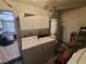 A functional laundry room with washer, dryer, cabinets, and hot water tank at 4437 Sherrill Ave, Las Vegas, NV 89110