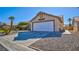 This single-Gathering home features a two car garage, desert landscaping and mature palm trees at 4653 Califa Dr, Las Vegas, NV 89122