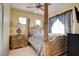 Well-lit bedroom featuring a four-poster bed, side table, and two bright windows at 4835 Willow Glen Dr, Las Vegas, NV 89147