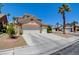 Inviting home exterior featuring a spacious driveway, a three-car garage, and desert landscaping at 4835 Willow Glen Dr, Las Vegas, NV 89147