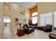 Elegant living room featuring soaring ceilings, an open staircase, and dining room view at 4835 Willow Glen Dr, Las Vegas, NV 89147