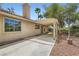 Private backyard featuring a covered patio, mature trees, and lush surroundings at 5529 Cranwood Ct, Las Vegas, NV 89130
