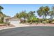 View of the charming home with a desert landscape, mature trees, and a two-car garage at 5529 Cranwood Ct, Las Vegas, NV 89130