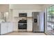 Updated kitchen features stainless appliances, white cabinetry, and bright natural light at 5529 Cranwood Ct, Las Vegas, NV 89130