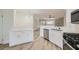 Open kitchen with white cabinets, stainless appliances, stylish lighting, and wood-look flooring at 5529 Cranwood Ct, Las Vegas, NV 89130