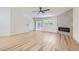 Bright open living room with wood-look floors, fireplace, ceiling fan, and large sliding glass door at 5529 Cranwood Ct, Las Vegas, NV 89130