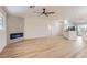 Spacious living room featuring a modern fireplace, ceiling fan, wood-look flooring, and a half wall to kitchen at 5529 Cranwood Ct, Las Vegas, NV 89130
