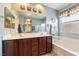 Bathroom featuring dual sinks, dark wood cabinets, shower and a bath at 565 Mazelle Ln, Pahrump, NV 89060