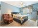 This bedroom features a ceiling fan, a plush chair, and natural light at 565 Mazelle Ln, Pahrump, NV 89060