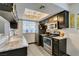Functional kitchen featuring stainless steel appliances, granite countertops, and dark wood cabinets for meal preparation at 5831 Medallion Dr # 103, Las Vegas, NV 89122
