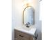 Elegant bathroom vanity with wood cabinets, white countertop, arched mirror, and matte black faucet at 6170 W University Ave, Las Vegas, NV 89103