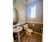 Half bathroom with a pedestal sink, toilet, and decorative window, offering style and functionality at 6545 Netherseal Ave, Las Vegas, NV 89139