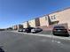 View of townhomes featuring ample parking, neutral color schemes, and well-maintained exteriors under a clear blue sky at 6545 Netherseal Ave, Las Vegas, NV 89139