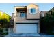 Two-story home with a two car garage, balcony, and neutral colored facade at 6545 Netherseal Ave, Las Vegas, NV 89139