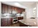 Kitchen featuring stainless steel appliances, stone countertops and dark brown cabinets at 68 E Serene Ave # 224, Las Vegas, NV 89123