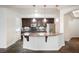 Kitchen with stone floors, large island, stainless steel appliances and dark cabinets at 68 E Serene Ave # 224, Las Vegas, NV 89123