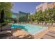Inviting community pool with plenty of seating, greenery, and scenic views of modern architecture at 68 E Serene Ave # 224, Las Vegas, NV 89123