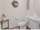 A modern half bath is decorated with wood floors, painted walls, framed pictures, and a pedestal sink at 6848 Sunflower Fields St, North Las Vegas, NV 89086