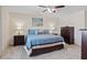 Comfortable bedroom with blue bedding, neutral carpet and wood dresser with nightstands at 6848 Sunflower Fields St, North Las Vegas, NV 89086